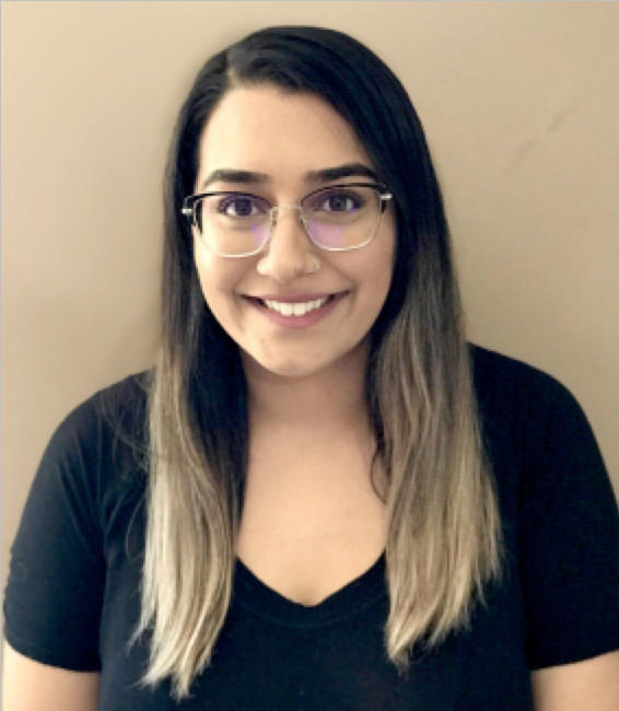 A headshot of Gurvaan. She has long, balayage hair that is dark at the roots and gradually transitions to light blonde. She is wearing a black t-shirt and glasses and is smiling.