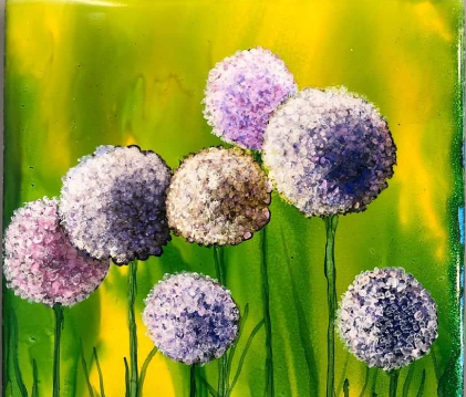 A painting of purple flowers in a field. The flowers are close-up and are puffy and spherical, in different shapes of violent and pinkish purple. A few stalks of grass extend from the bottom of the painting. In the background, soft yellows and greens suggest a sunlight forest. The artist is Irma Van Oirschot.